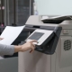 Woman's hand press button on panel of printer at office.